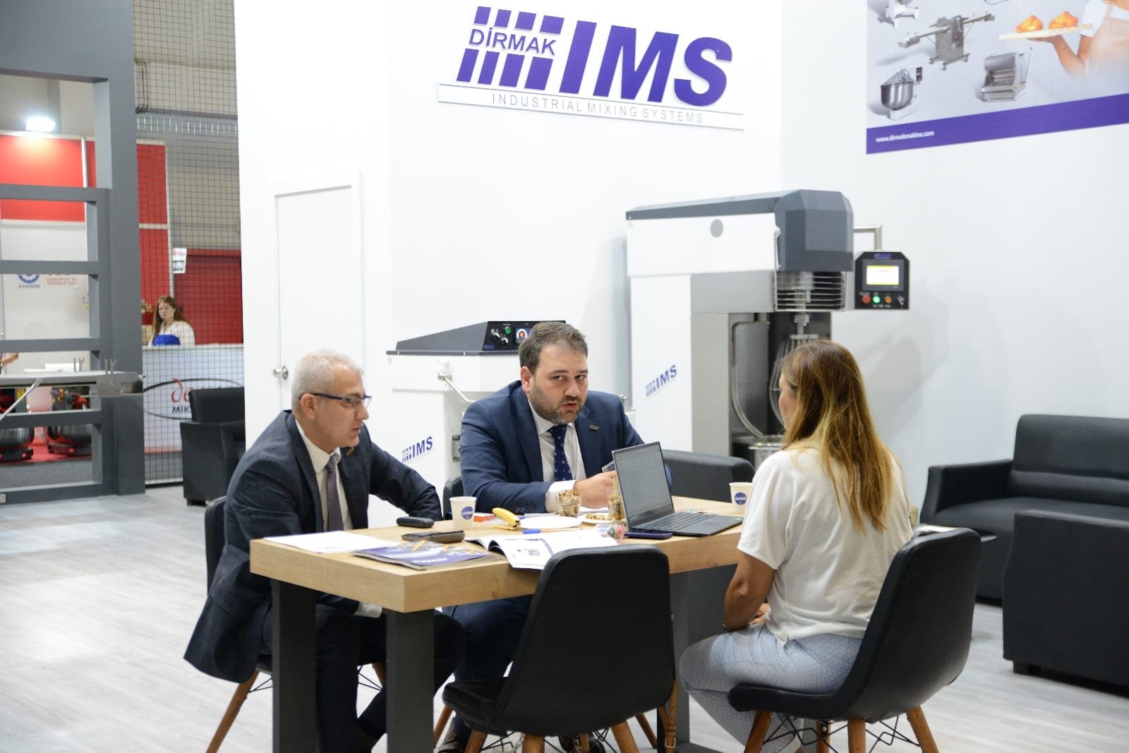 Trade-partner conversation at a Dirmak Makina booth during an international food-machinery fair.